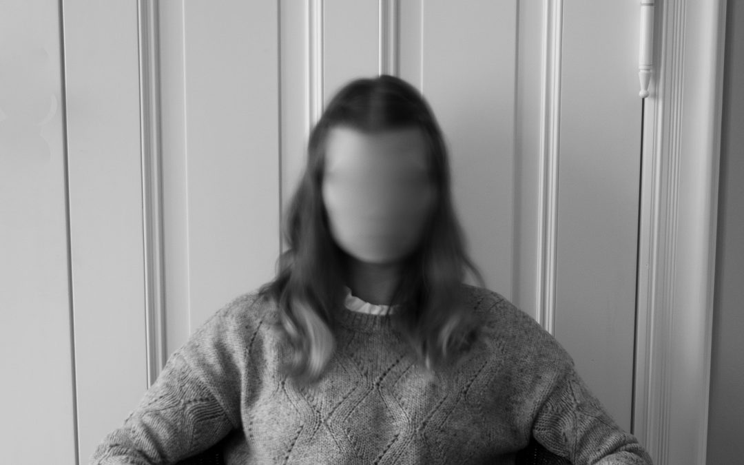 Black and white image of a woman with her face blurred
