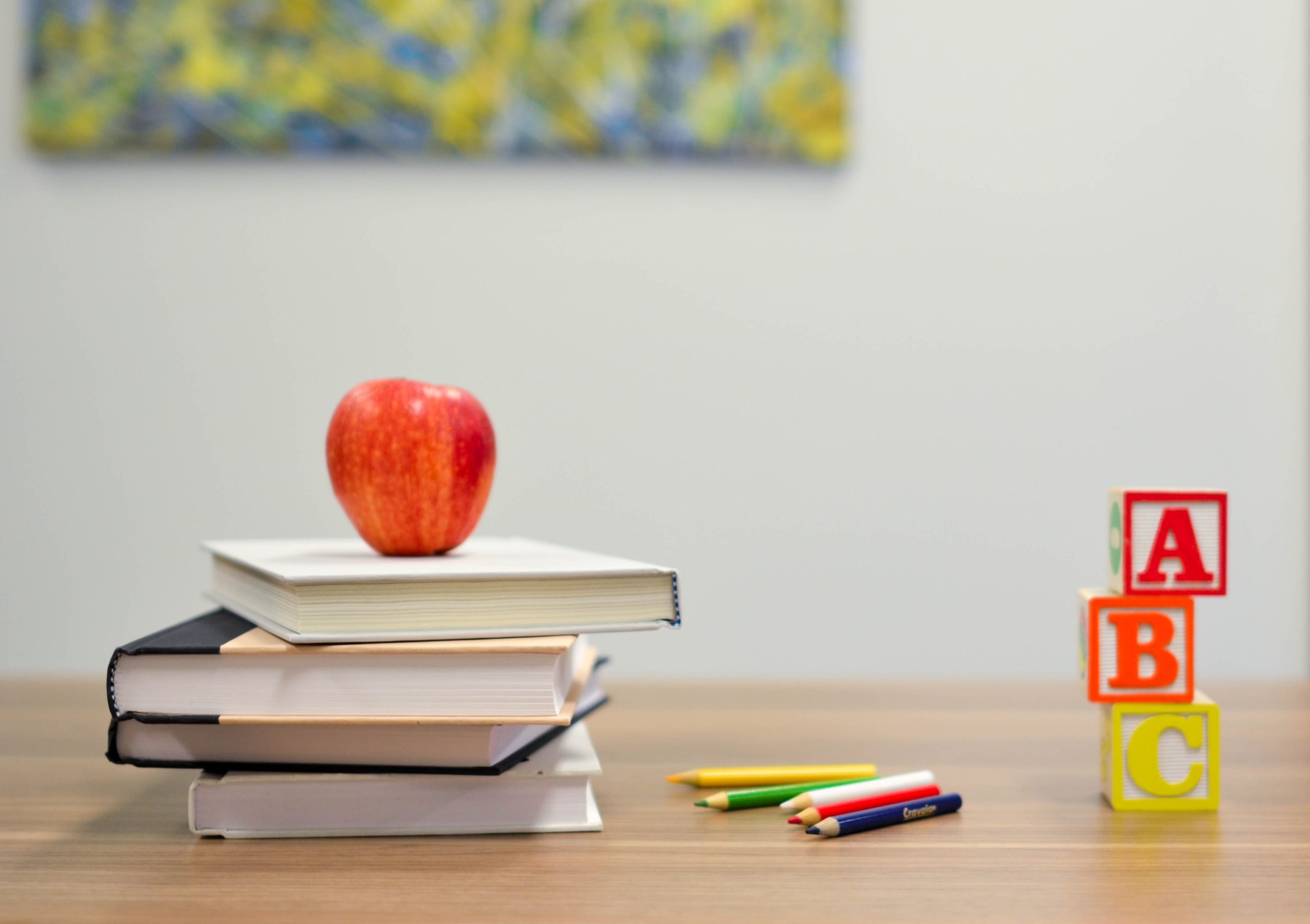Apple, books, and pencil on desk