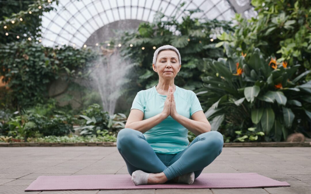 a woman sitting in a lotus pose with her hands together