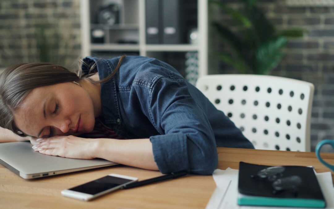 A young girl falling asleep at her desk on a table