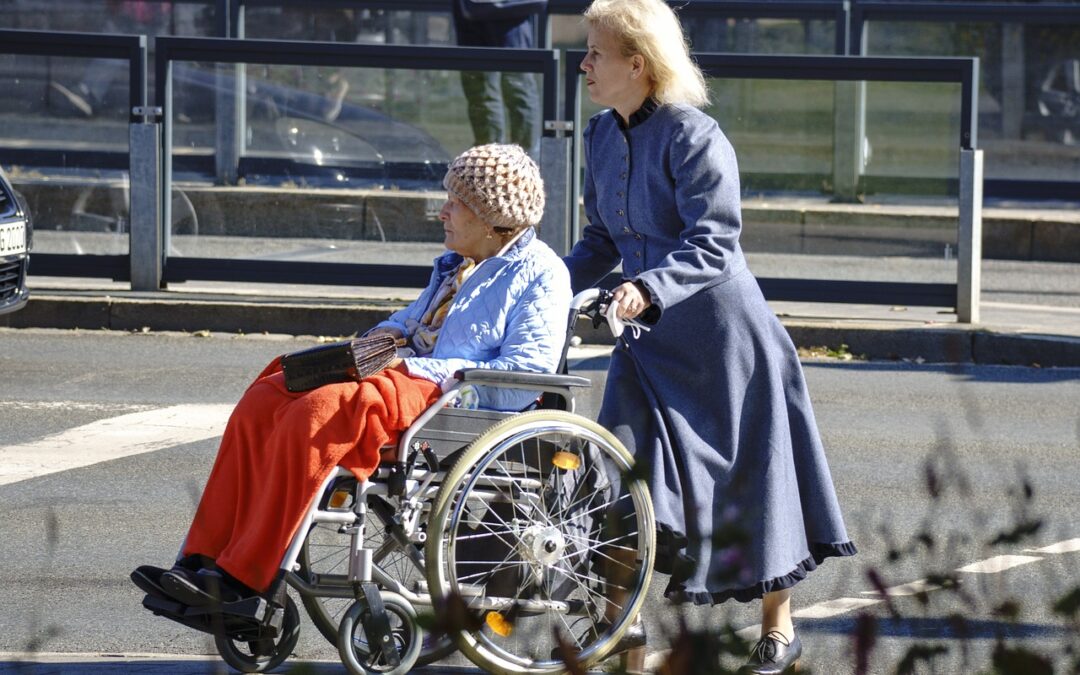 Caregiver helping elderly person in wheelchair