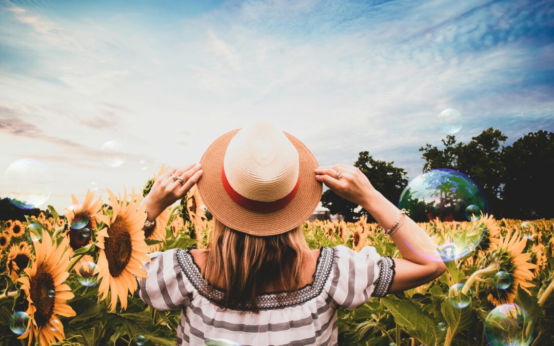 A woman with a hat on a sunflower field, overcoming mental health challenges
