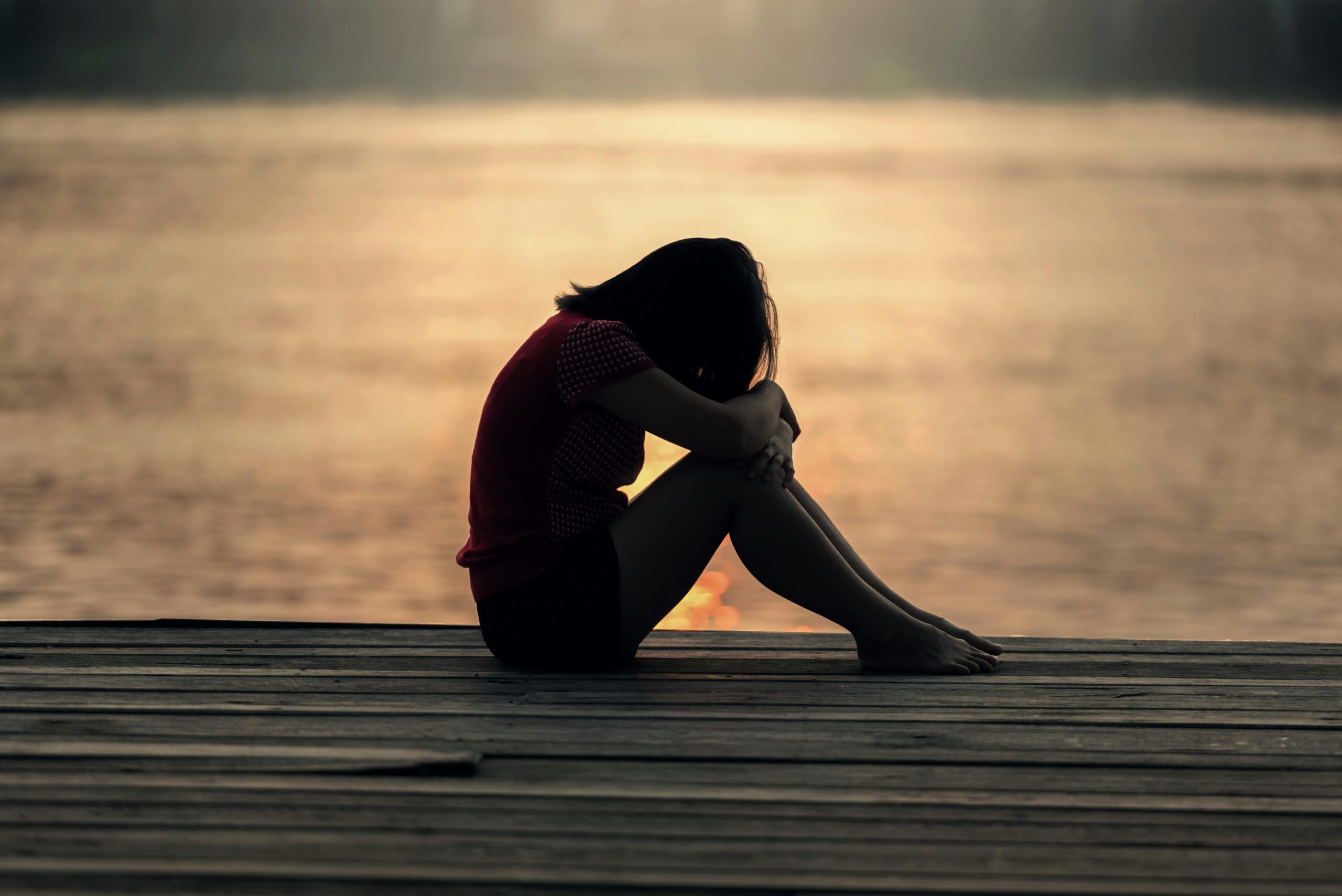 Woman Experiencing Grief by the Water